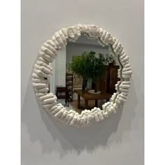 a round mirror hanging on the wall above a table