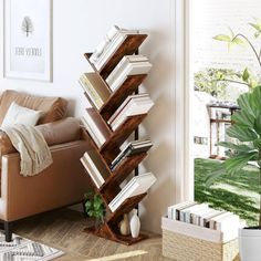 a living room filled with furniture and a tall book shelf next to a couch in front of a window