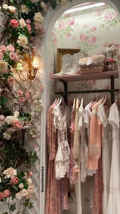 the closet is full of clothes and flowers on display in front of an arched doorway