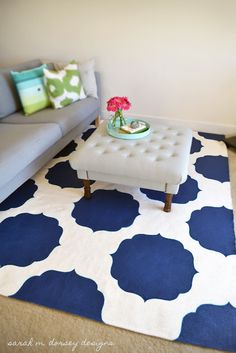 a living room with a blue and white rug on the floor next to a couch