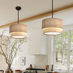 two lamps hanging from the ceiling in a kitchen