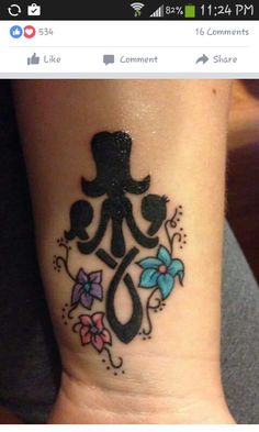 a woman's wrist with a tattoo on it that has an image of a top hat and flowers