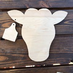 a wooden cutout of a cow and a bird sitting on top of wood planks