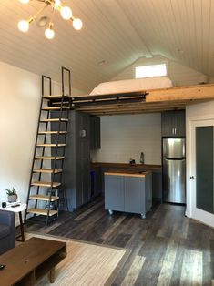 a loft with stairs leading up to the kitchen