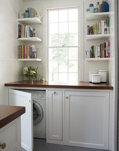 a washer and dryer in a room with bookshelves on the wall