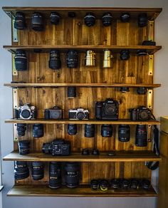 a wooden shelf filled with lots of cameras