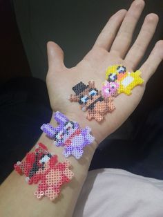 a person's hand with four pixelated characters on it