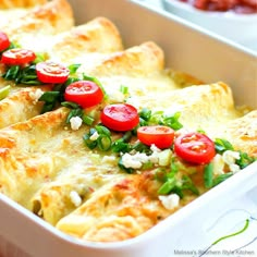 a casserole dish with tomatoes and spinach garnish