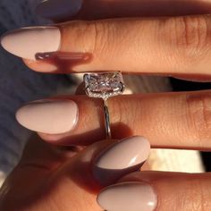 a woman's manicured nails with a ring on her finger and a diamond in the middle