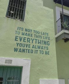 a green building with graffiti written on it's side and the words, it's not to late to make this life everything you've always wanted it to be