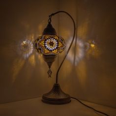 a lamp that is sitting on top of a table next to a wall with lights behind it