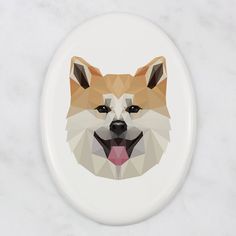 a white and brown dog's face on an oval shaped porcelain button or magnet