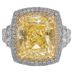 An impeccable and well-crafted engagement ring, featuring a vibrant 8.77 carats cushion cut diamond certified by GIA as Light Yellow color and VS clarity, set with a double halo of yellow and white diamonds. Flanked by two epaulette cut diamonds set in a diamond encrusted split-shank in a half-eternity design. Accented by rows of white diamonds set in a three-dimensional micropavé setting. Accent white diamonds weigh 2.34 carats total, and accent yellow diamonds weigh 0.27 carat total. Finely ma Three Stone Engagement Rings Halo, Canary Diamond, Double Halo Engagement Ring, Double Halo Engagement, Emerald Cut Diamond Engagement, Contemporary Engagement Rings, Fancy Yellow Diamond, Engagement Ring Diamond Cut, Double Halo