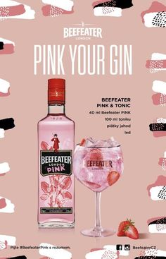 a bottle of pink gin next to a glass filled with ice and strawberries on a pink background