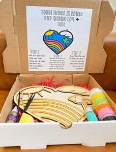 an open cardboard box filled with crafting supplies