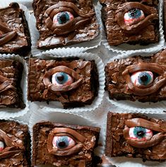 some brownies with chocolate frosting and blue eyes on them are arranged in rows