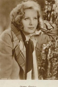 an old black and white photo of a woman wearing a neck tie with her hands on her head