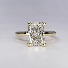 an engagement ring with a cushion cut diamond in the center, on a white background