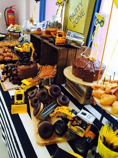 a table topped with lots of donuts covered in frosting and construction themed decorations