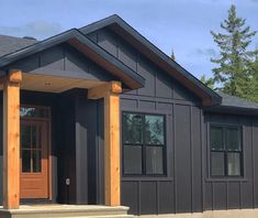 a gray house with wood trim and windows