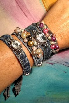 a close up of a person's arm wearing bracelets with pearls on them