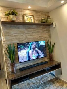 a flat screen tv sitting on top of a wooden entertainment center in a living room