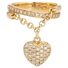 Stylish contemporary diamond heart charm ring crafted in 18 karat yellow gold (circa 2000s). Round brilliant cut diamonds total an estimated 0.50 carats (estimated at H-I color and SI1-I1 clarity). The ring highlights pave set sparkling diamonds on a dangling heart charm. Attached to a chain link the unique design of the ring allows the heart to dangle and move. Ideal worn alone as a statement ring and also a fun piece to stack together with your own bands. The low rise ring (2mm - 0.07 inches) Double Heart Ring, Charm Ring, Diamond Heart Ring, Pave Diamond Ring, Ringe Gold, Gold Band Ring, Modern Ring, Charm Rings, White Gold Band