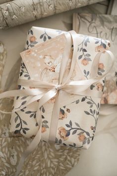 a gift wrapped in floral paper with a ribbon