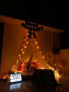 a birthday party with balloons, lights and a teepee tent for the number twenty five