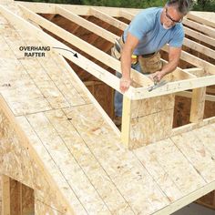 a man is working on framing the roof of a house that's being built