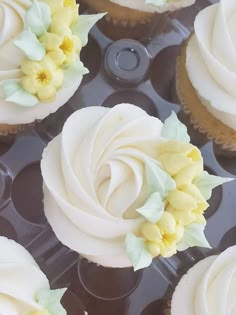 several cupcakes with white frosting and yellow flowers