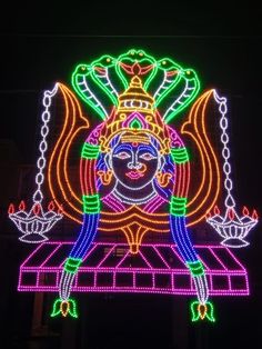 an illuminated statue is shown in the dark with colorful lights on it's face