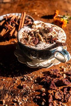 two cups filled with food sitting on top of a wooden table next to cinnamon sticks