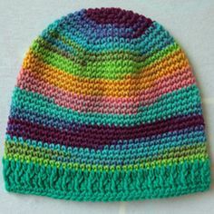 a multicolored crocheted hat sitting on top of a white surface