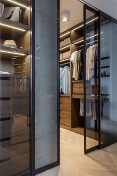 a walk in closet with glass doors and shelves