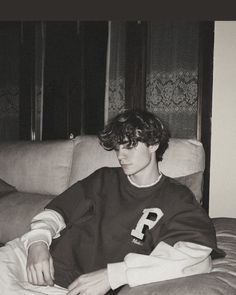 a young man sitting on top of a couch