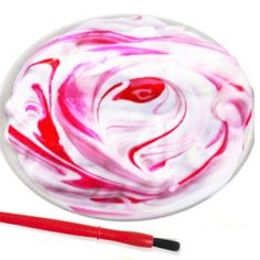 a red and white swirled object next to a brush