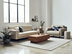 a living room with two couches and a coffee table in front of a large window