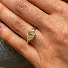 a close up of a person's hand with a diamond ring on their finger