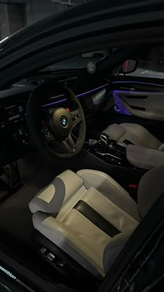 the interior of a car with leather seats and steering wheel, illuminated by blue lights