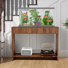 a record player sitting on top of a wooden table next to a stair case with plants in it