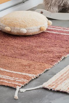 a rug with a pillow on top of it next to a stuffed animal and other items