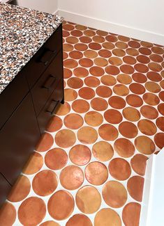 a bathroom with an orange and white floor that has circles painted on the ground in different colors