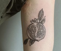 a pomegranate tattoo on the arm