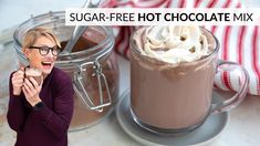 a woman holding a cup of hot chocolate with whipped cream on top and the words sugar - free hot chocolate mix