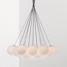 a chandelier with five white balls hanging from it's center and four on each side