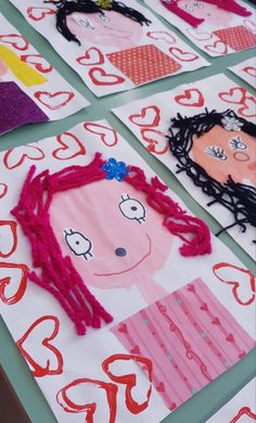 paper cut out of children's faces are displayed on a table with red and pink hearts