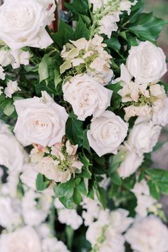 a bouquet of white flowers with green leaves