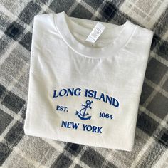 Long Island New York embroidered Crewneck Long Island New York Est 1664 with a doodle of an Anchor in the center on an White crewneck embroidery in blue threads. This crew neck is very cozy and has a classic look to match any outfit. UNISEX SIZING- fits true to size. Order up for an oversized fit 80/20 cotton/polyester blend fleece Every item is made in our studio Please allow up to 7 business days for your order to ship. Blue Embroidered Crew T-shirt, Blue Crew T-shirt With Embroidered Graphics, Blue Crew Neck T-shirt With Custom Embroidery, Blue Crew T-shirt With Custom Embroidery, Vintage Cotton Tops With Letter Embroidery, Vintage Embroidered Crew Neck T-shirt, Crewneck Embroidery, Long Island New York, White Crewneck