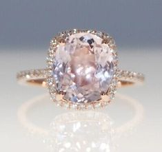 an engagement ring with a pink diamond in the center and pave diamonds around it